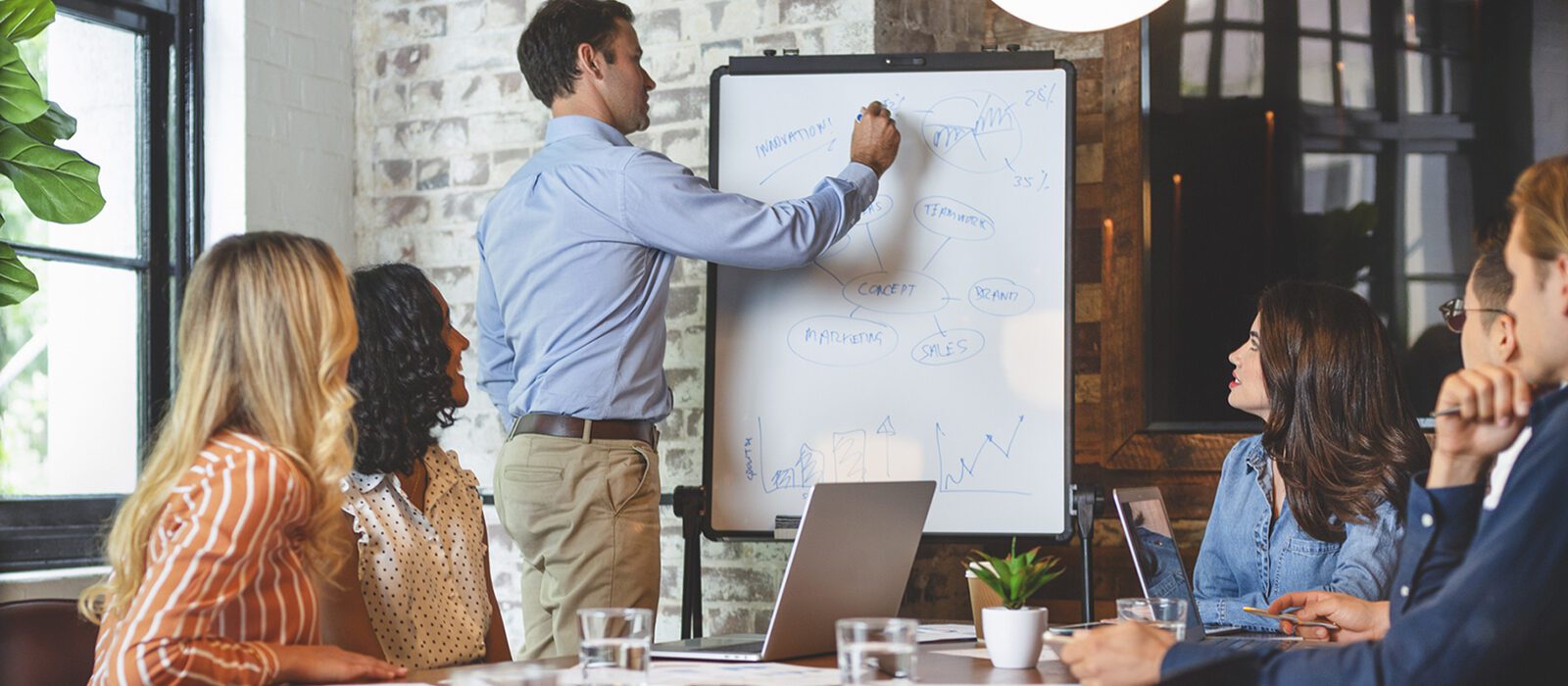 Business people watching presenter writing on the whiteboard.