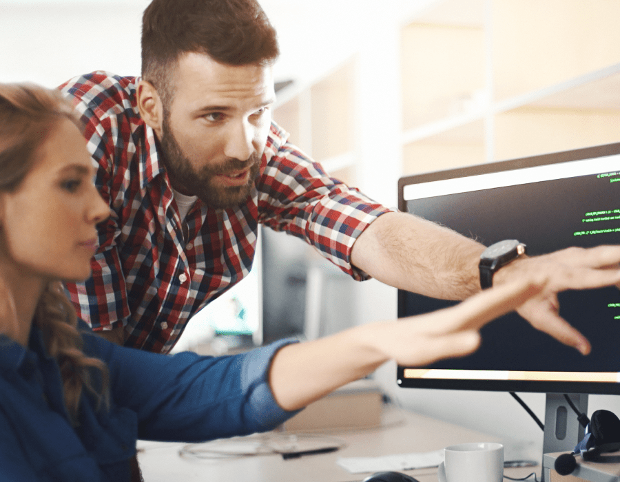 Profile view of a man and women troubleshooting issues with application code.