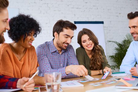 Group of people around a conference table reviewing mobile app POC.