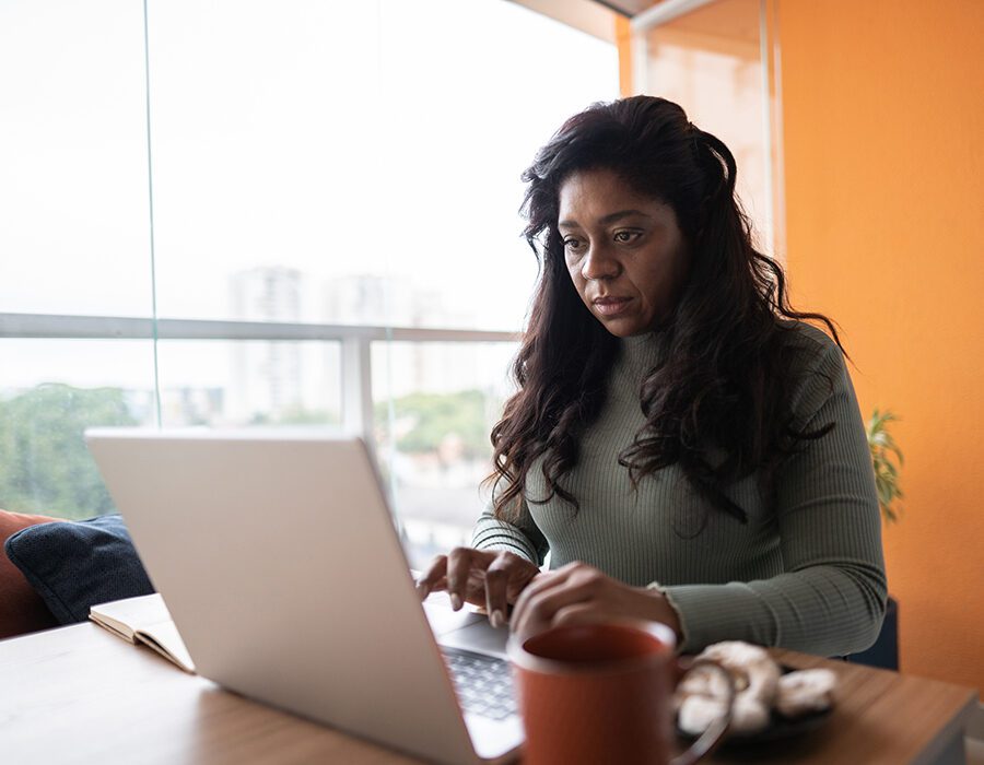 Person working at table using laptop.