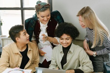 Cheerful colleagues working together around a laptop.