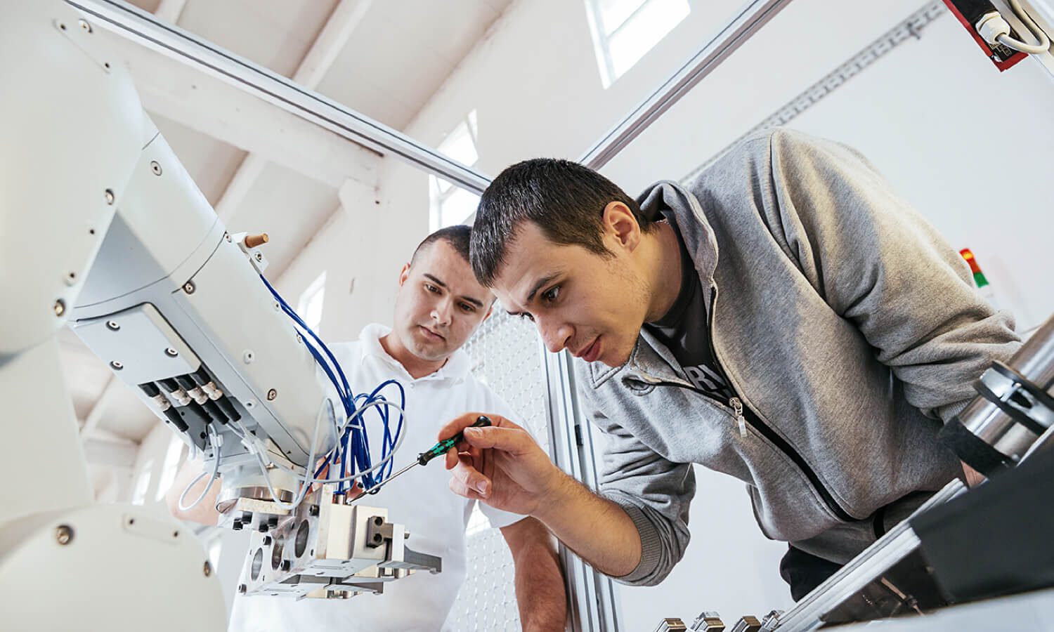 Engineers working on development of automated production line with robotic parts.