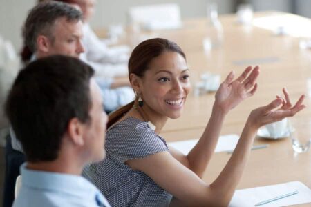 woman speaking to colleagues in a boardroom