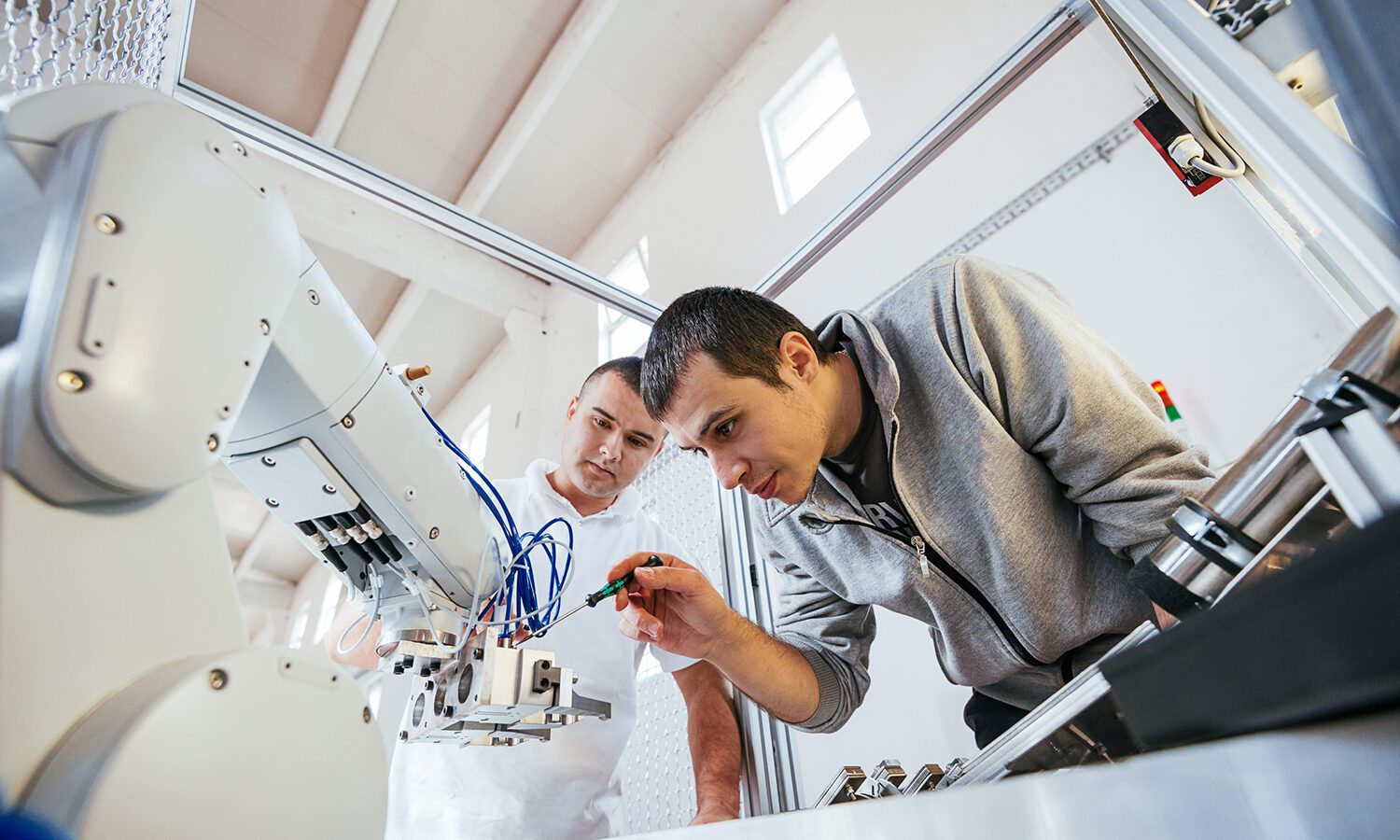 Engineers working on development of automated production line with robotic parts.