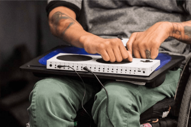 Man in a wheelchair using an accessibility gaming controller.