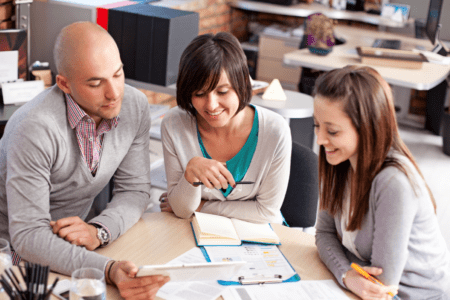 Colleagues sitting at table reviewing information.