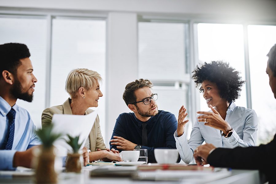 Group of business people sitting at a table having a discussion.