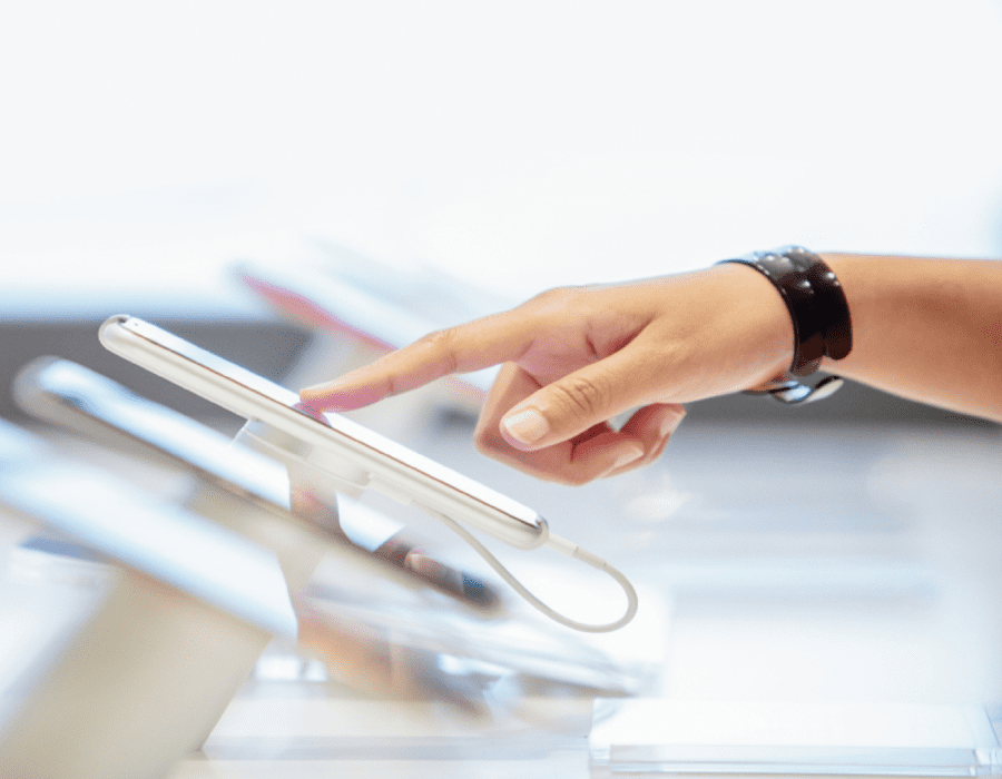 Close-up of a pointing hand interacting with several mobile devices comparing the different features.