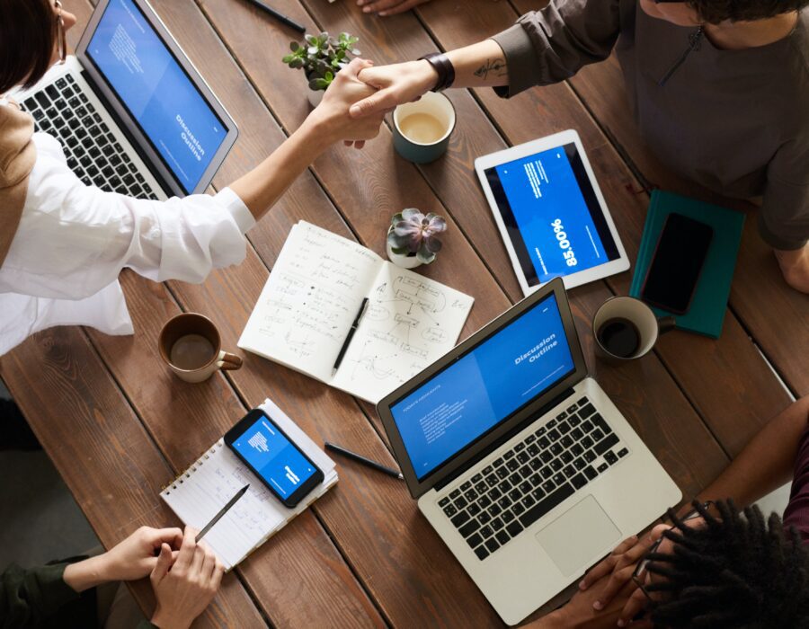 people collaborating around a table full of laptops