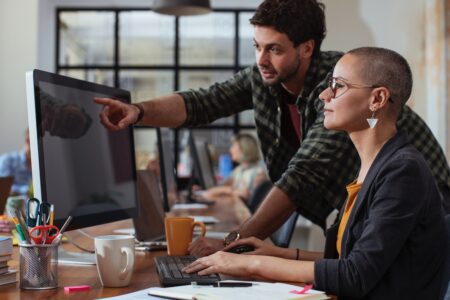 Two colleagues in an office talking.