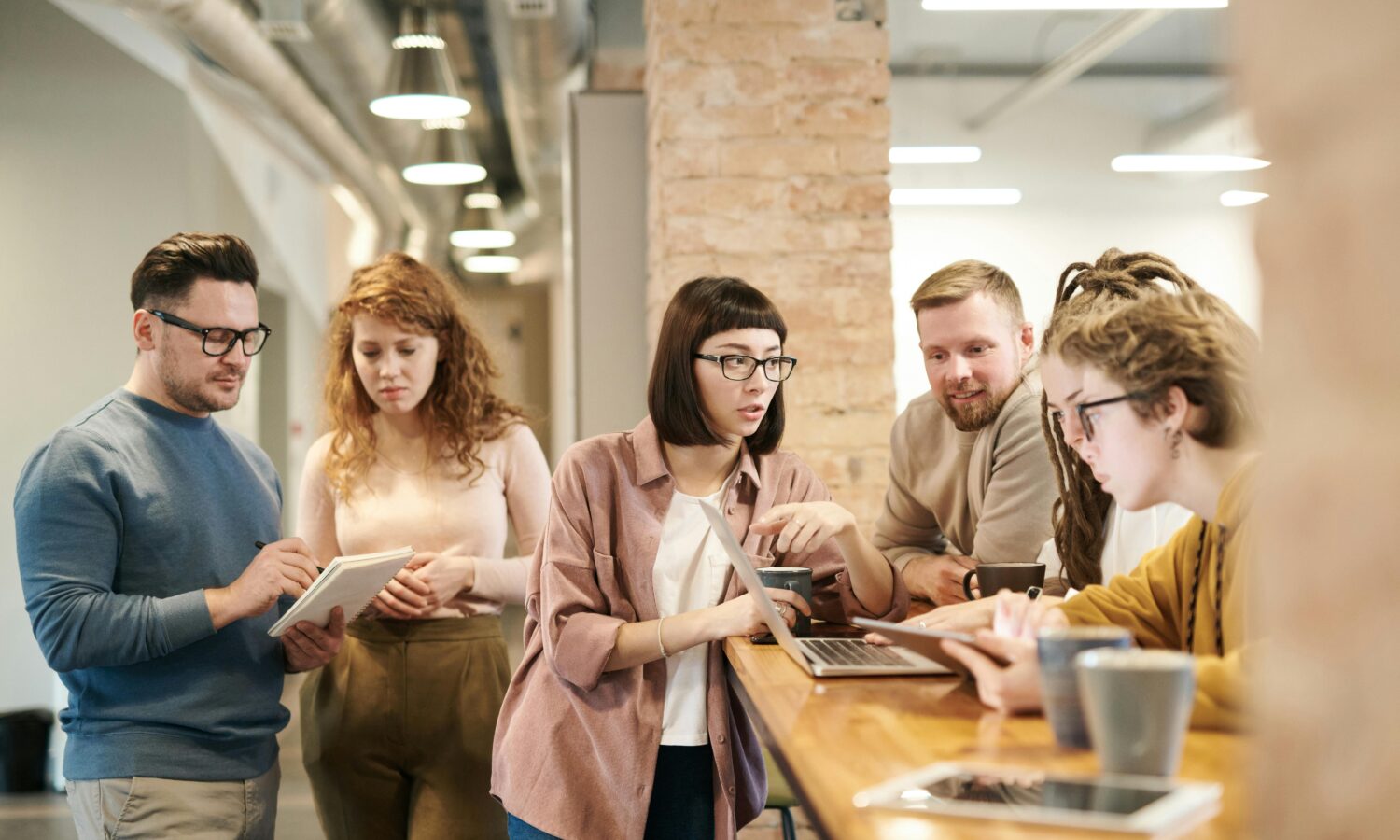 A group of colleagues talking in an informal office setting.
