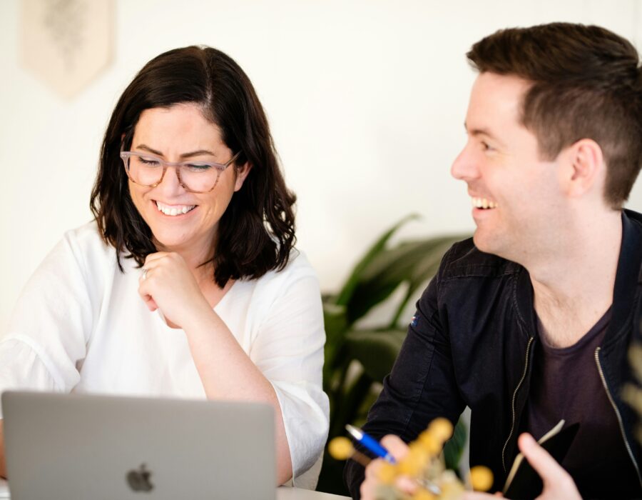Man and woman talking over a laptop