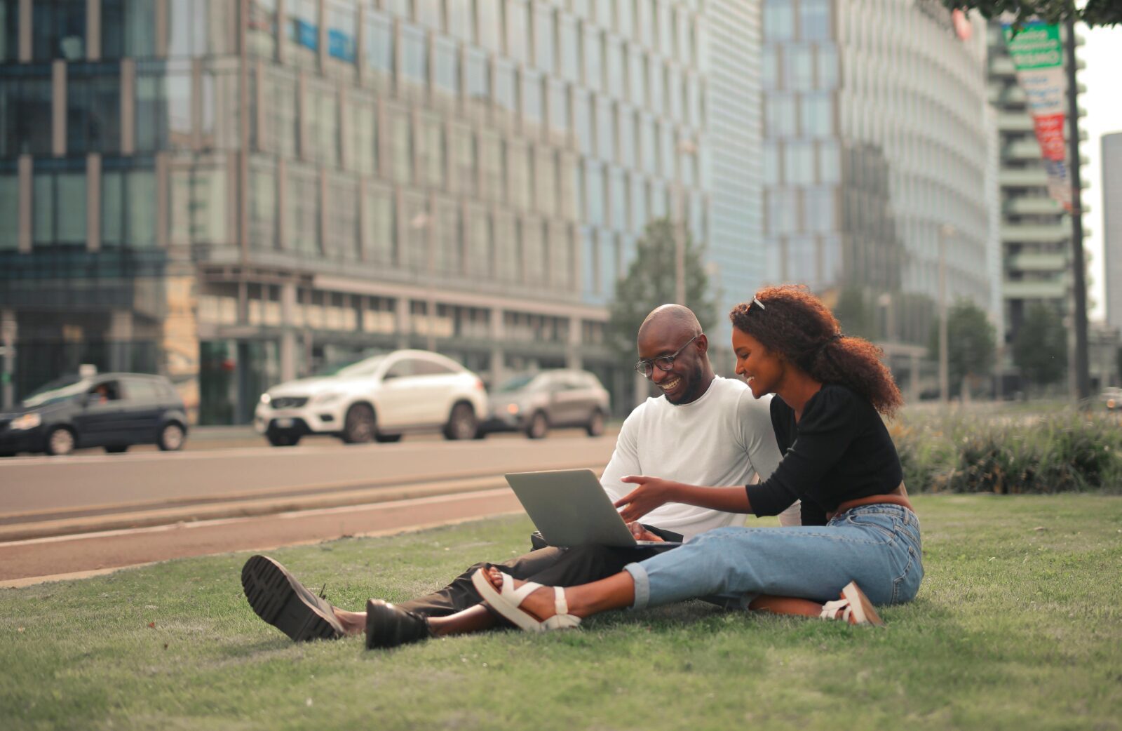 Man and woman working outdoors over a laptop