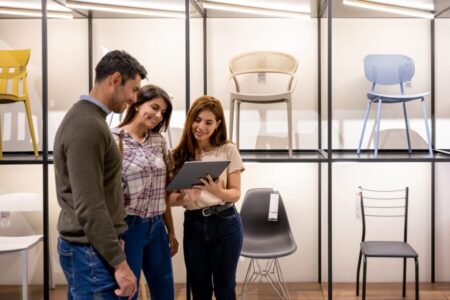 Retail salesperson uses an AI product recommendation chatbot to help a couple buy chairs for their house at a furniture store